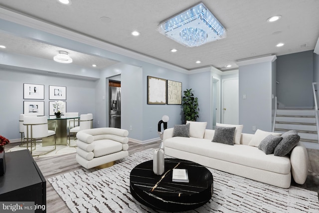 living room featuring crown molding, light hardwood / wood-style floors, and a notable chandelier