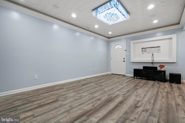 entryway with crown molding, a textured ceiling, and light wood-type flooring