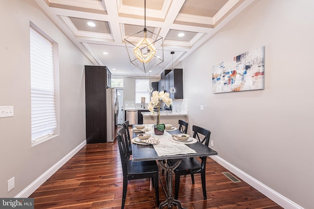 dining space featuring beam ceiling, coffered ceiling, dark hardwood / wood-style flooring, a notable chandelier, and ornamental molding