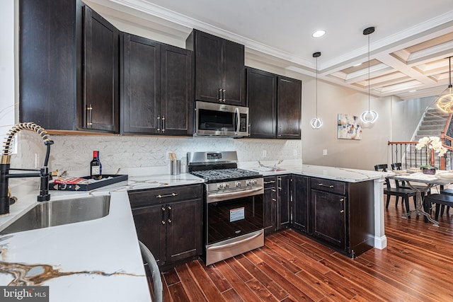 kitchen featuring sink, hanging light fixtures, stainless steel appliances, coffered ceiling, and ornamental molding