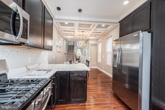 kitchen featuring coffered ceiling, crown molding, hanging light fixtures, appliances with stainless steel finishes, and beam ceiling