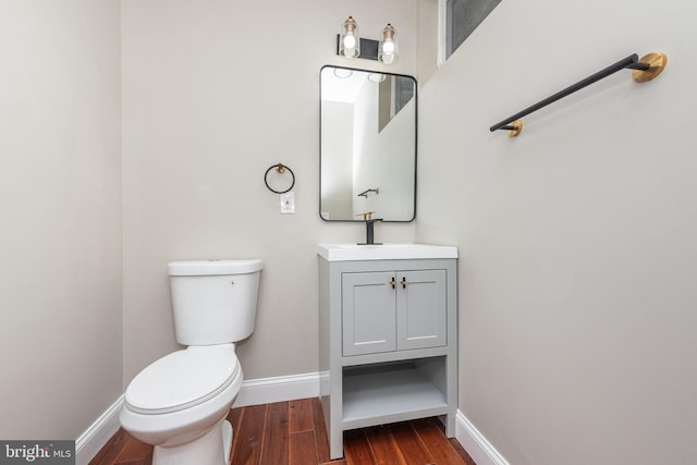 bathroom with hardwood / wood-style floors, vanity, and toilet