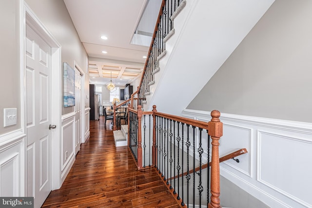 hallway featuring beamed ceiling, dark hardwood / wood-style floors, a notable chandelier, and coffered ceiling