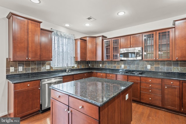 kitchen featuring hardwood / wood-style flooring, a center island, sink, and stainless steel appliances