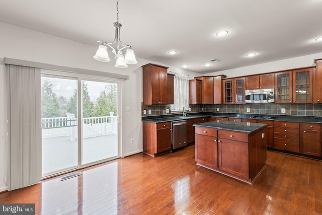 kitchen with a center island, dark hardwood / wood-style flooring, stainless steel appliances, and tasteful backsplash