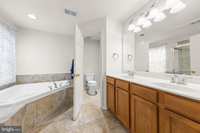 bathroom featuring vanity, toilet, and tiled tub