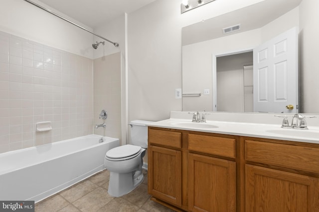 full bathroom featuring toilet, vanity, tile patterned floors, and tiled shower / bath combo