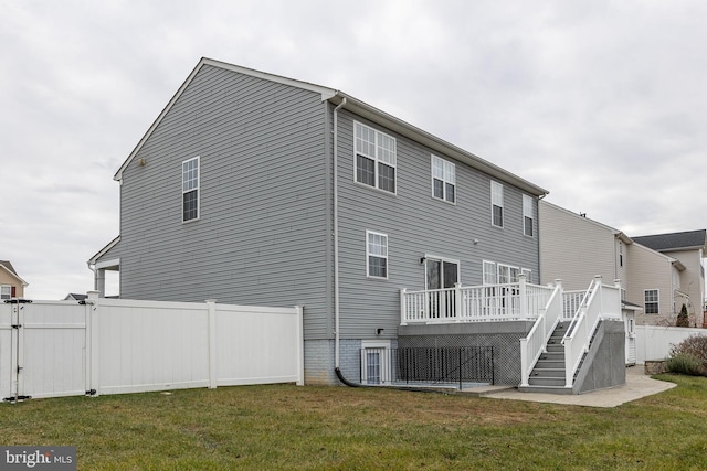 back of property featuring a deck and a yard