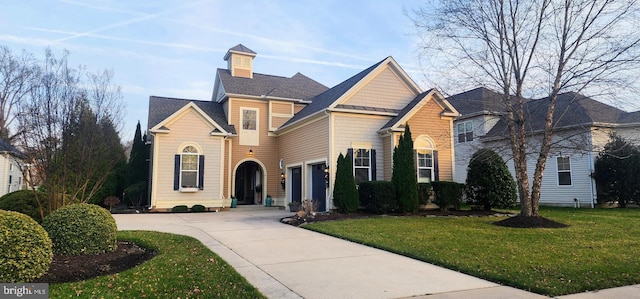 view of property with a garage and a front lawn