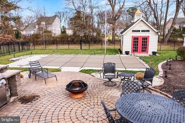 view of patio with an outbuilding and a fire pit