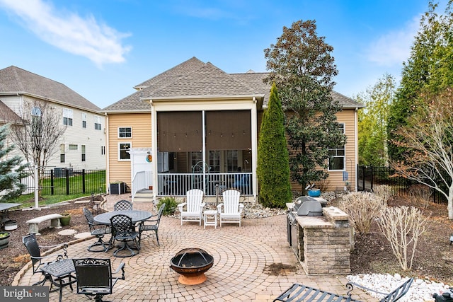 back of house with a sunroom, a patio, an outdoor fire pit, and central AC