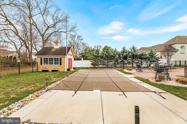 exterior space with a yard, an outdoor structure, a covered pool, and a patio area