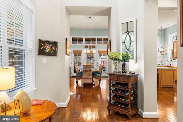 hallway with french doors, sink, dark hardwood / wood-style floors, and a notable chandelier