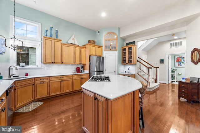 kitchen with stainless steel appliances, sink, a notable chandelier, a center island, and hanging light fixtures