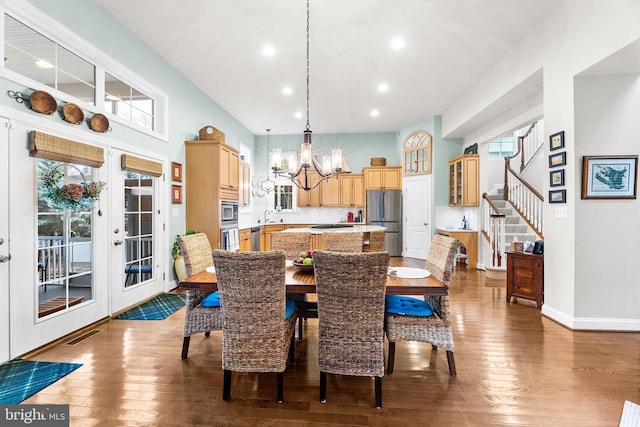 dining room with sink, light hardwood / wood-style flooring, french doors, and an inviting chandelier