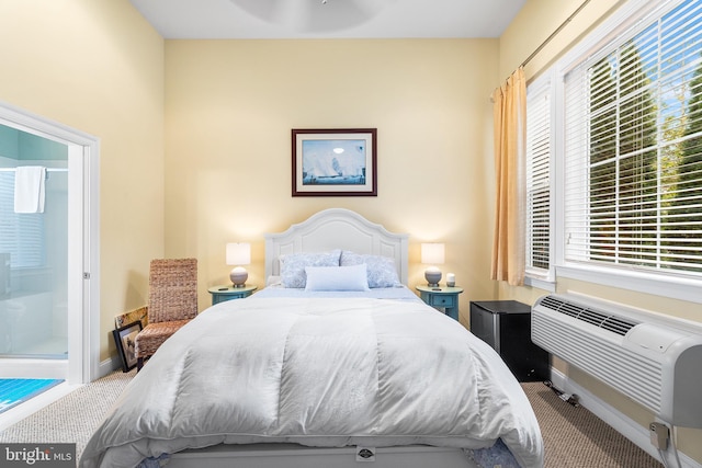 carpeted bedroom featuring ensuite bath, ceiling fan, and a wall mounted air conditioner