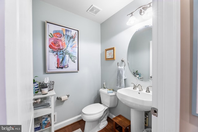 bathroom with hardwood / wood-style floors and toilet