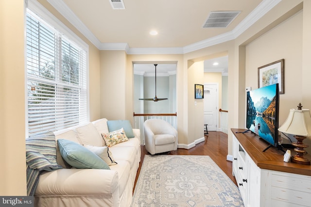 sitting room with wood-type flooring and crown molding