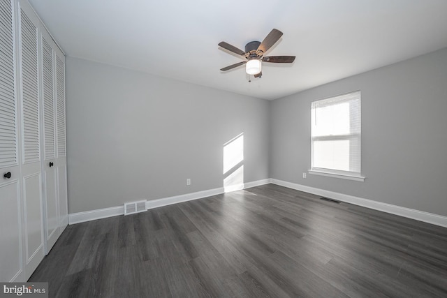 unfurnished bedroom featuring a closet, ceiling fan, and dark hardwood / wood-style flooring