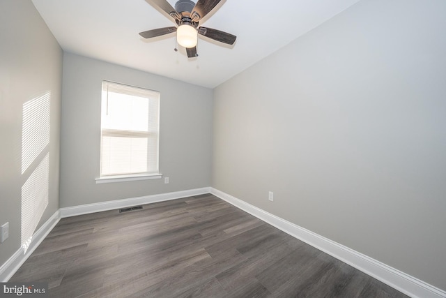 empty room with dark hardwood / wood-style flooring and ceiling fan