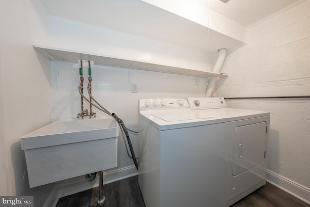 laundry room featuring washing machine and dryer, sink, and dark hardwood / wood-style floors