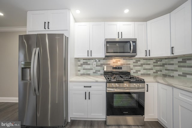 kitchen with dark hardwood / wood-style floors, appliances with stainless steel finishes, tasteful backsplash, light stone counters, and white cabinetry