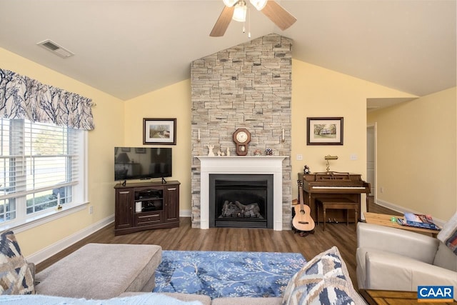 living room featuring a stone fireplace, ceiling fan, lofted ceiling, and hardwood / wood-style flooring