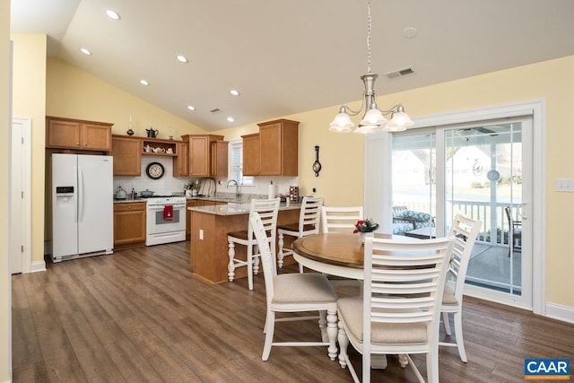 dining room with dark hardwood / wood-style flooring, sink, high vaulted ceiling, and an inviting chandelier