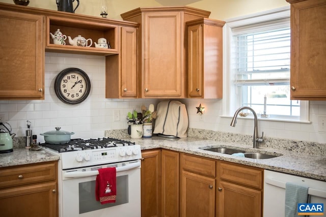 kitchen featuring white appliances, backsplash, a wealth of natural light, and sink