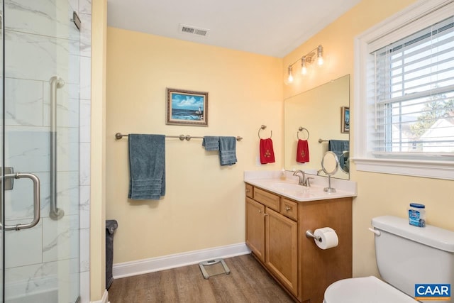 bathroom featuring toilet, a shower with door, vanity, and hardwood / wood-style flooring