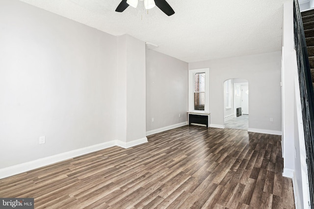 unfurnished living room with ceiling fan, dark wood-type flooring, and a textured ceiling