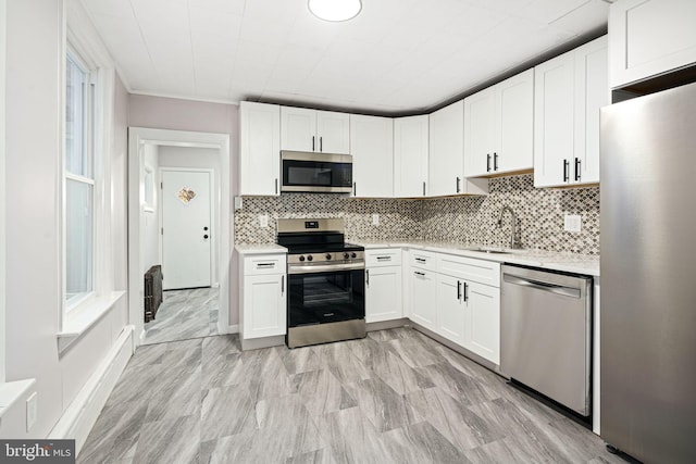 kitchen featuring tasteful backsplash, white cabinetry, sink, and stainless steel appliances