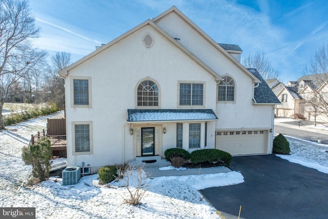 view of front property with central AC unit and a garage