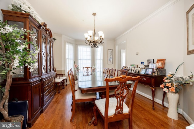 dining room featuring hardwood / wood-style floors, an inviting chandelier, and ornamental molding