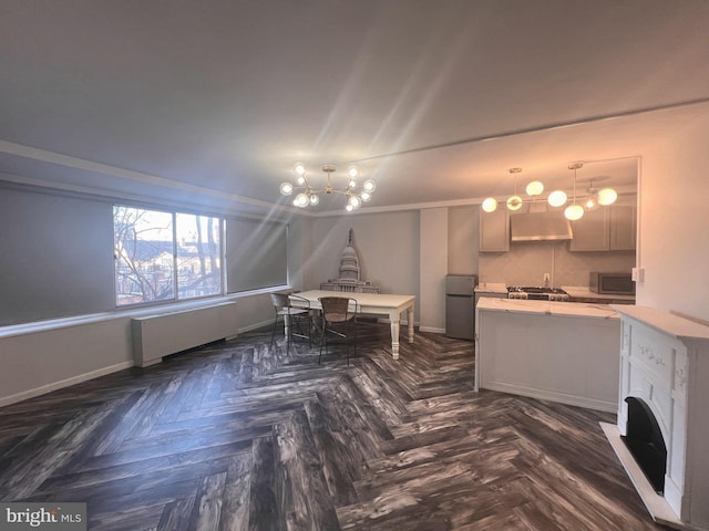 interior space with dark parquet floors, radiator heating unit, and stainless steel fridge