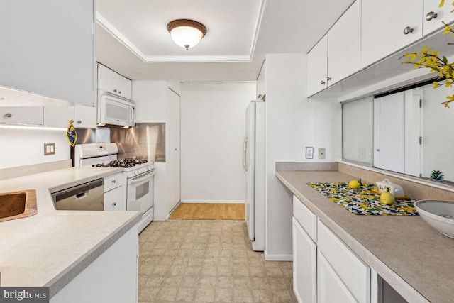 kitchen featuring sink, white cabinets, and white appliances