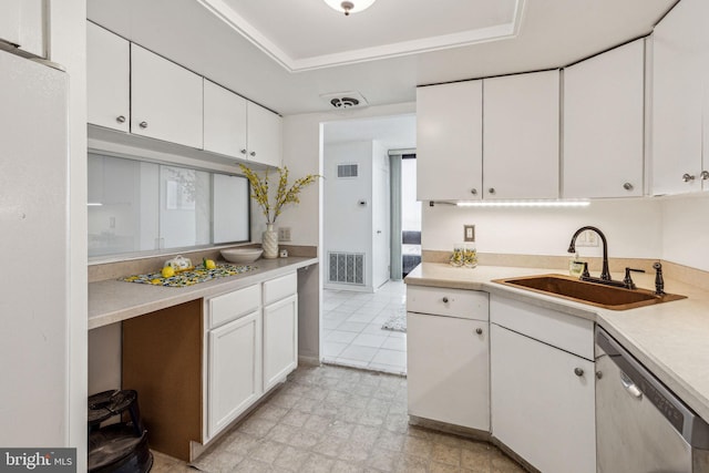 kitchen featuring a tray ceiling, white cabinetry, stainless steel dishwasher, and sink