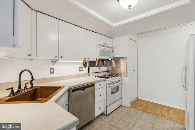 kitchen with light wood-type flooring, white appliances, white cabinetry, and sink