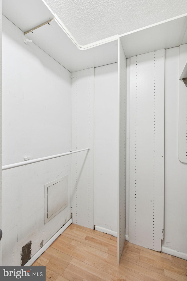 walk in closet with hardwood / wood-style floors