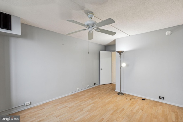 spare room featuring ceiling fan, a textured ceiling, and light wood-type flooring