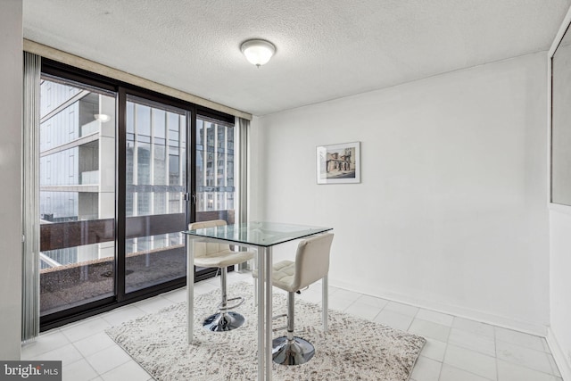 dining space with floor to ceiling windows, light tile patterned floors, and a textured ceiling