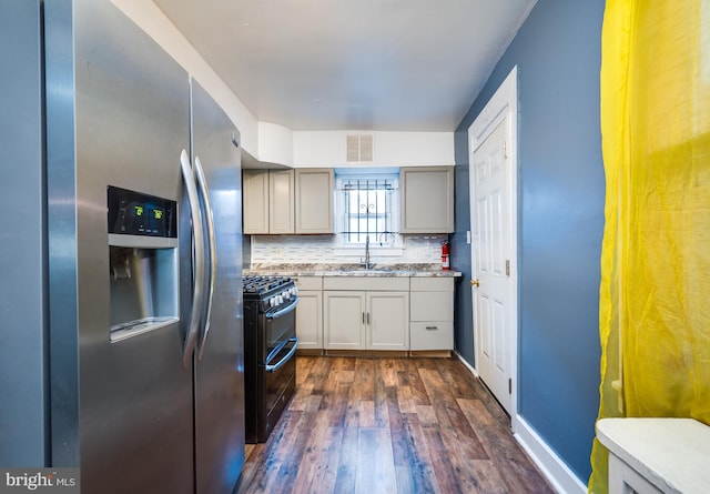 kitchen featuring backsplash, black range with gas stovetop, sink, stainless steel fridge with ice dispenser, and dark hardwood / wood-style floors