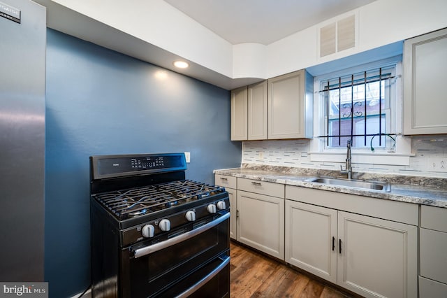 kitchen with backsplash, dark wood-type flooring, sink, gray cabinets, and range with gas stovetop