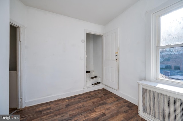 unfurnished room with radiator heating unit and dark wood-type flooring