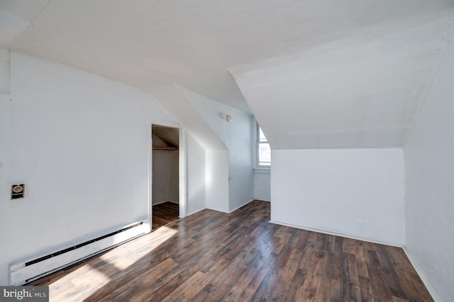 additional living space with dark wood-type flooring, lofted ceiling, and a baseboard heating unit