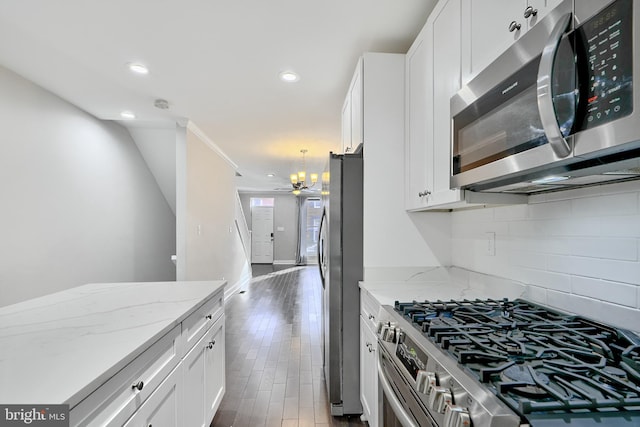 kitchen featuring light stone counters, white cabinets, dark wood-type flooring, and appliances with stainless steel finishes