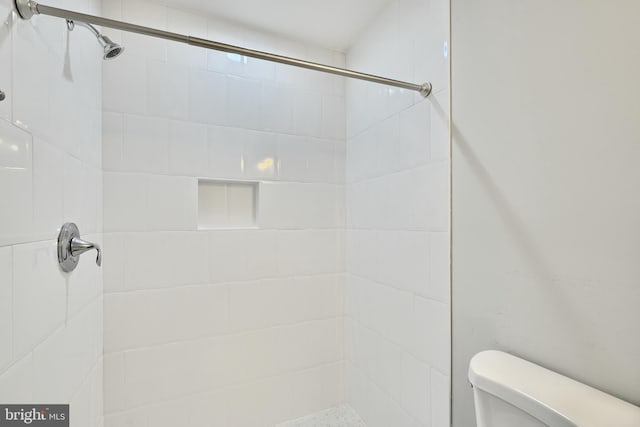 bathroom with tiled shower and toilet