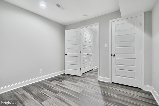 unfurnished bedroom with hardwood / wood-style flooring and a closet