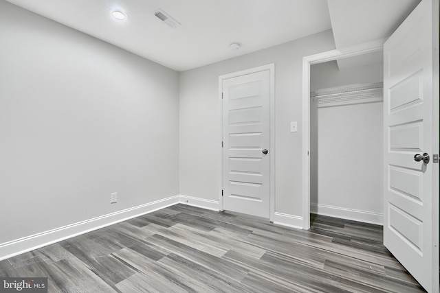 unfurnished bedroom featuring dark hardwood / wood-style floors and a closet