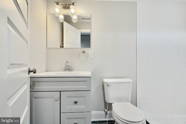 bathroom featuring tile patterned flooring, vanity, and toilet